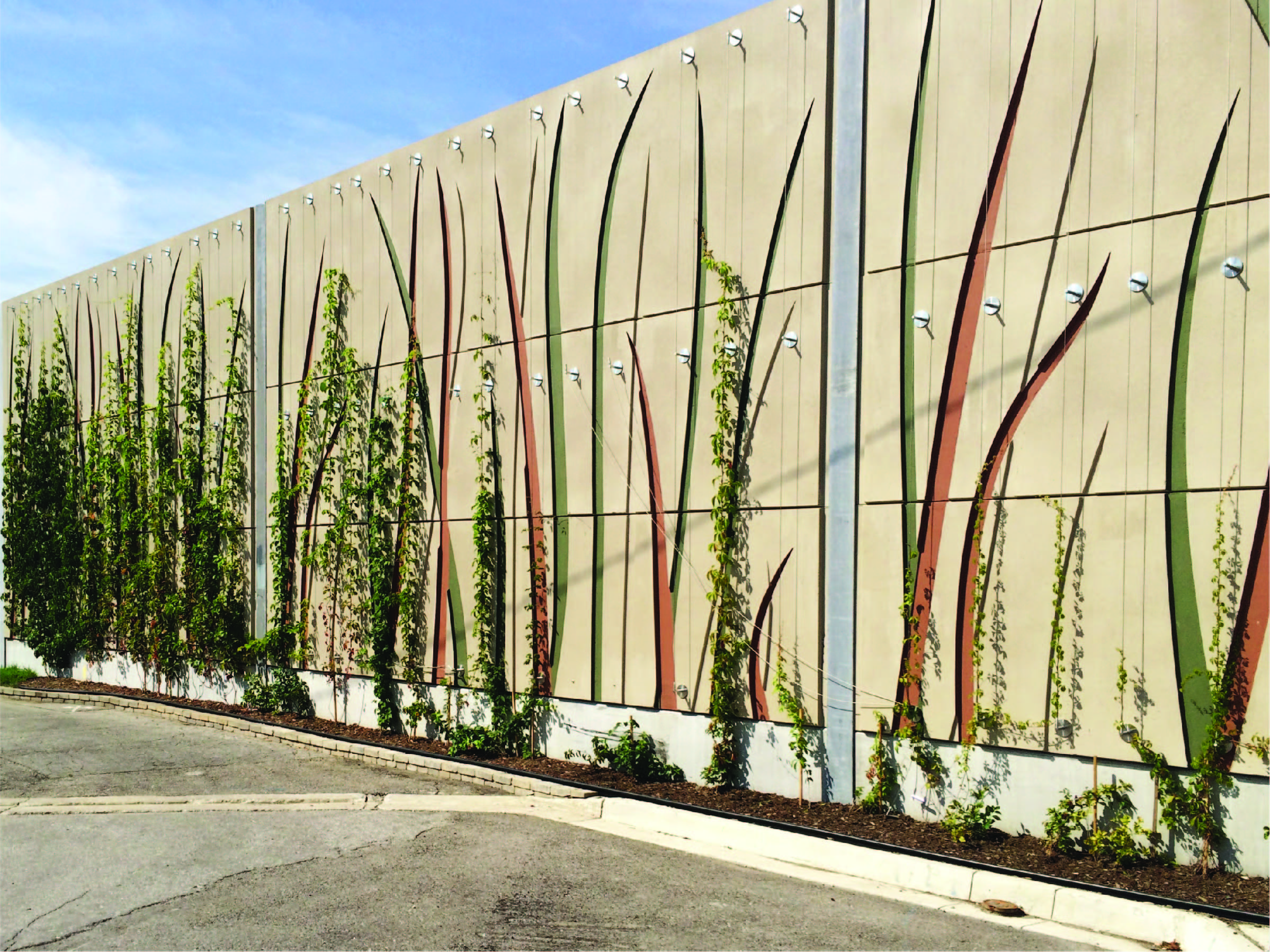 Noise barrier with Durisol absorptive panels featuring a custom "grasslands" pattern along Metrolinx's Union Pearson Express rail line in Toronto, ON.