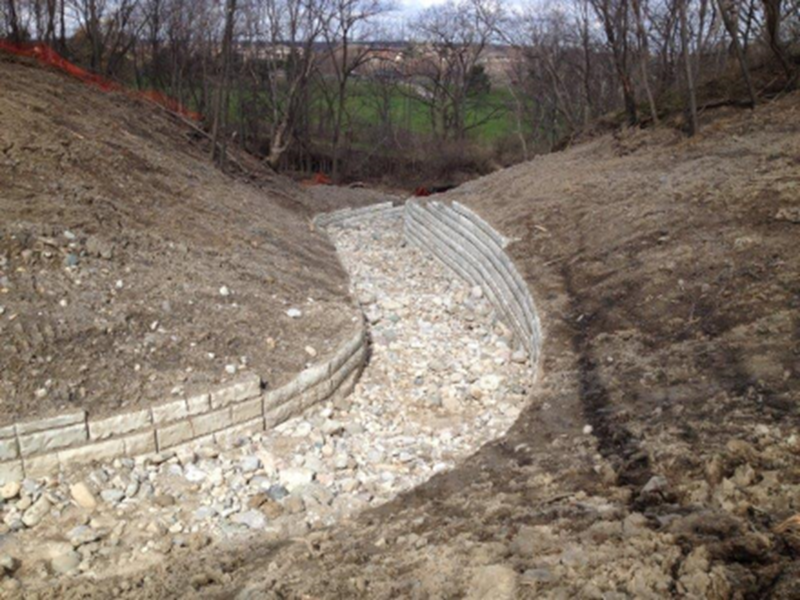 Preparing the site for a Retain-A-Rock retaining wall system at a water outfall channel in Hamilton, ON.