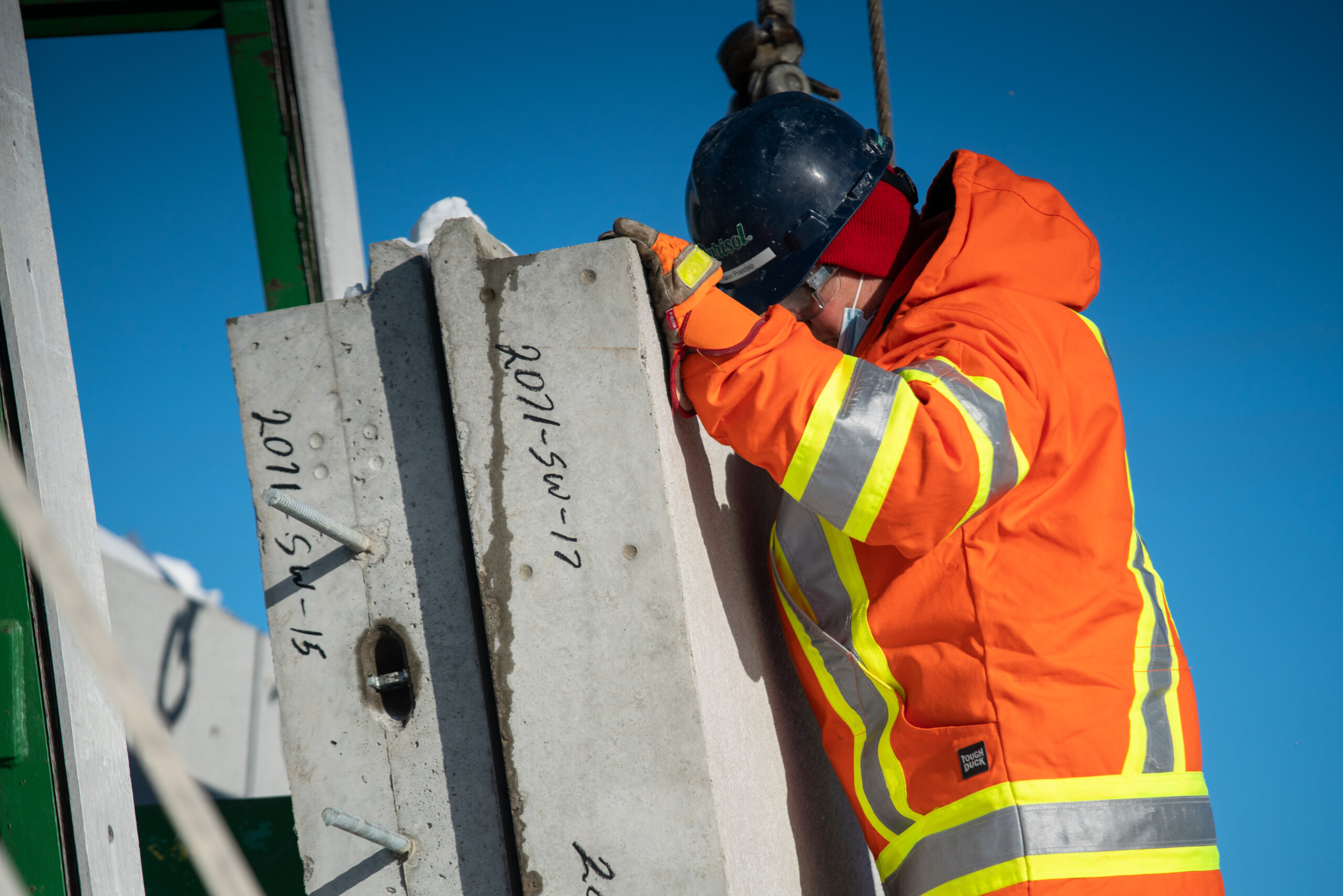 A precast manufacturing plant employee loading concrete panels for delivery. A precast manufacturing plant employee loading concrete panels for delivery.