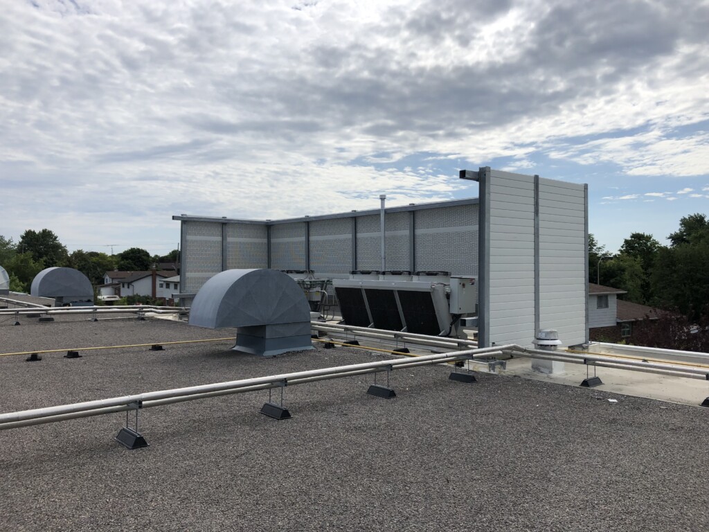 PVC post-and-panel rooftop noise barrier system on the roof of a food processing facility in the Greater Toronto Area, ON.
