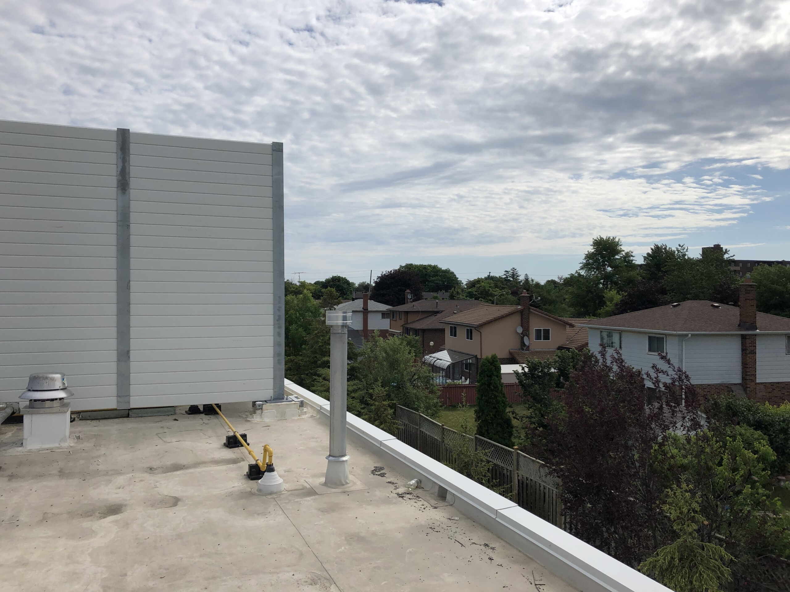 PVC post-and-panel rooftop noise barrier system on the roof of a food processing facility in the Greater Toronto Area, ON.