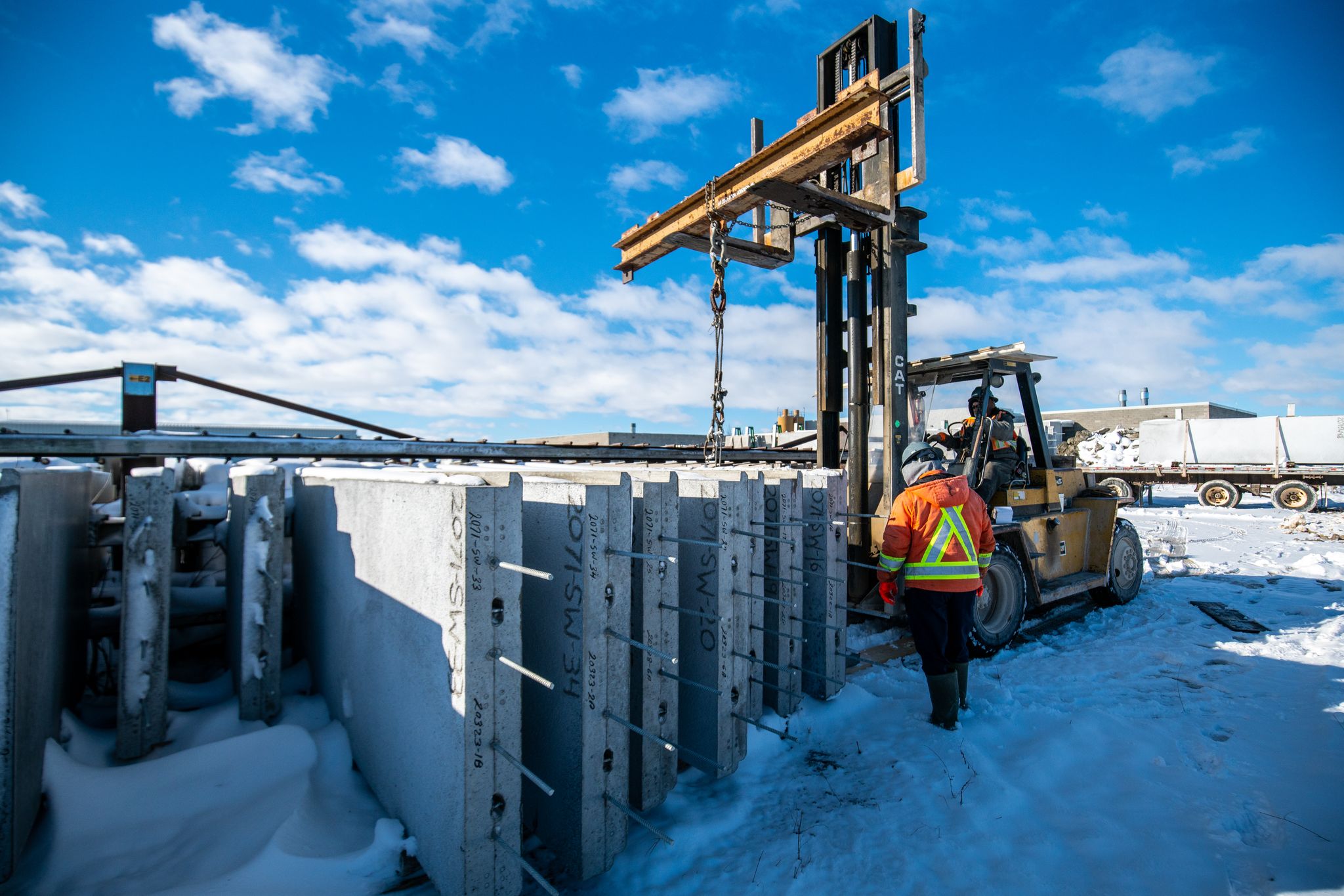 A precast manufacturing plant employee loading concrete panels for delivery.